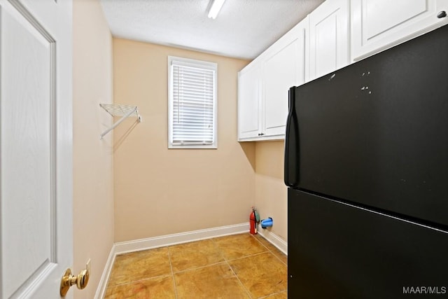 clothes washing area featuring baseboards and light tile patterned flooring