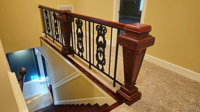 staircase featuring carpet floors and baseboards