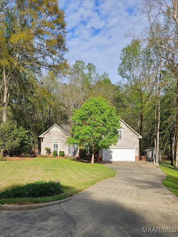 view of front of home featuring an attached garage, a front lawn, and driveway