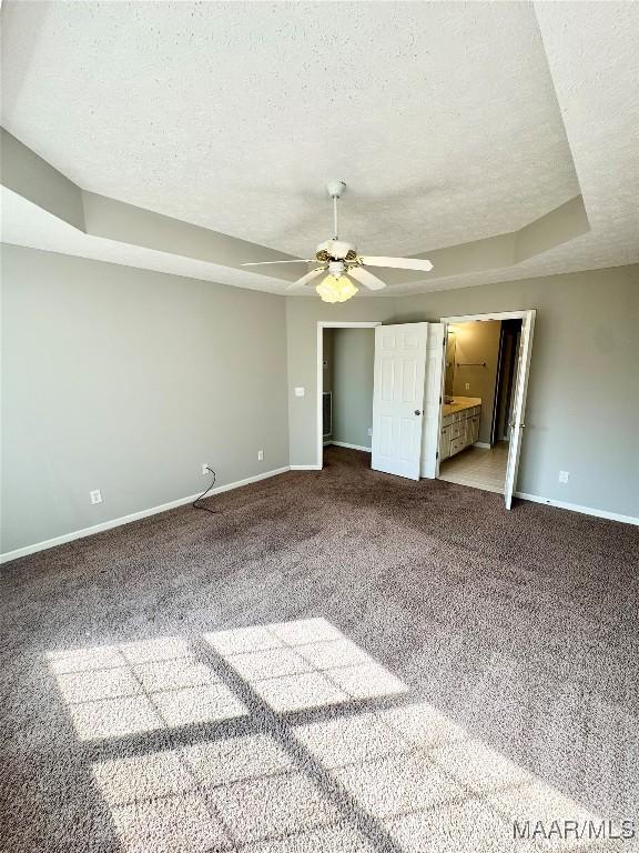 unfurnished bedroom featuring connected bathroom, a textured ceiling, carpet floors, and ceiling fan