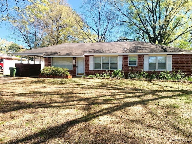 ranch-style home with a front yard and a carport