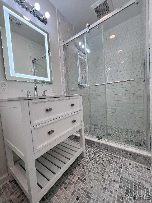 bathroom featuring vanity and a shower with shower door