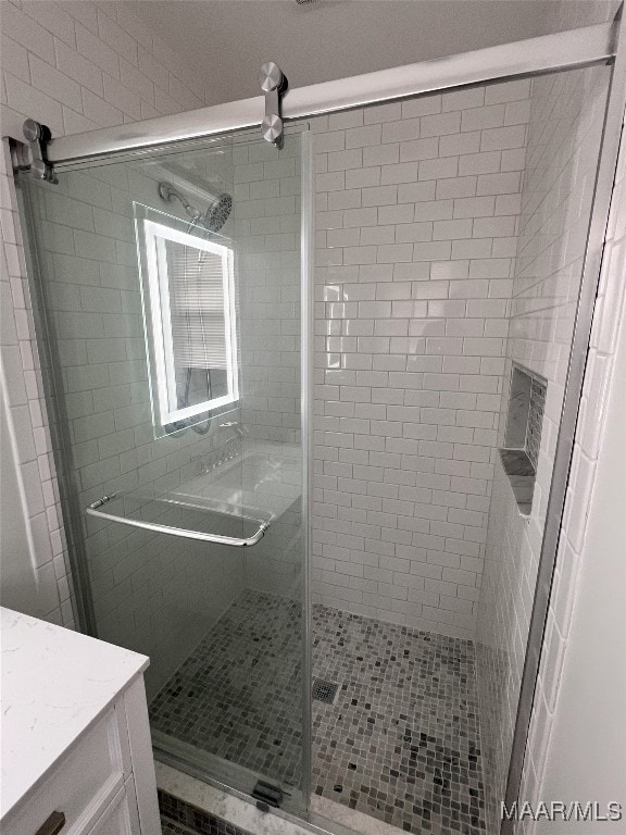 bathroom with vanity and a shower with shower door