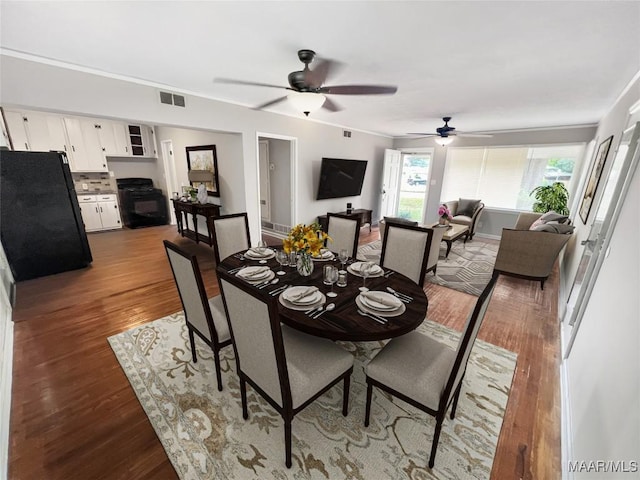 dining space featuring crown molding and dark wood-type flooring