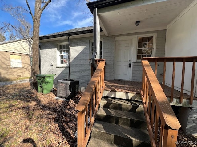 property entrance featuring a deck and central air condition unit