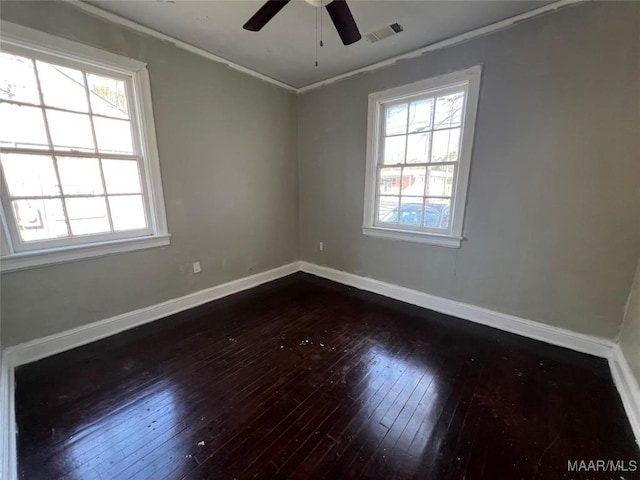 unfurnished room featuring crown molding, a healthy amount of sunlight, ceiling fan, and dark hardwood / wood-style flooring