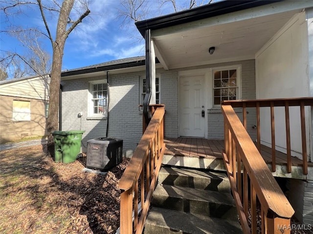 entrance to property with a wooden deck and central air condition unit