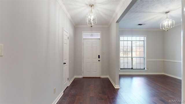 entrance foyer with ornamental molding, dark hardwood / wood-style flooring, and an inviting chandelier