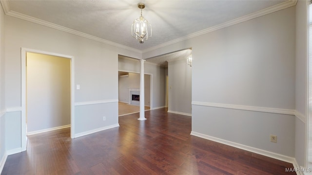 empty room featuring dark hardwood / wood-style flooring, crown molding, a textured ceiling, and ornate columns