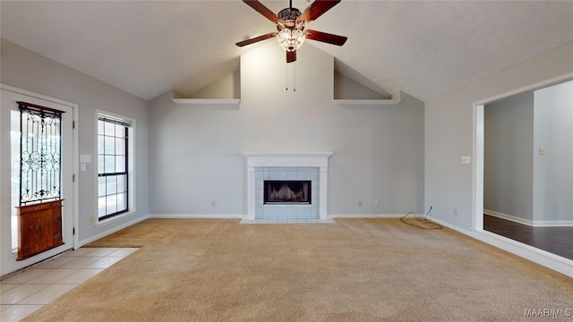 unfurnished living room with light carpet, a fireplace, vaulted ceiling, and ceiling fan