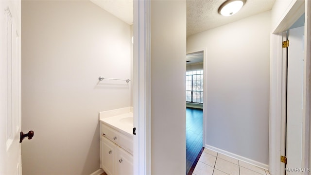 bathroom featuring tile patterned flooring, vanity, and a textured ceiling