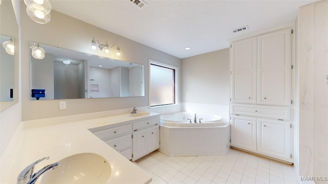 bathroom with vanity, tiled tub, and tile patterned floors