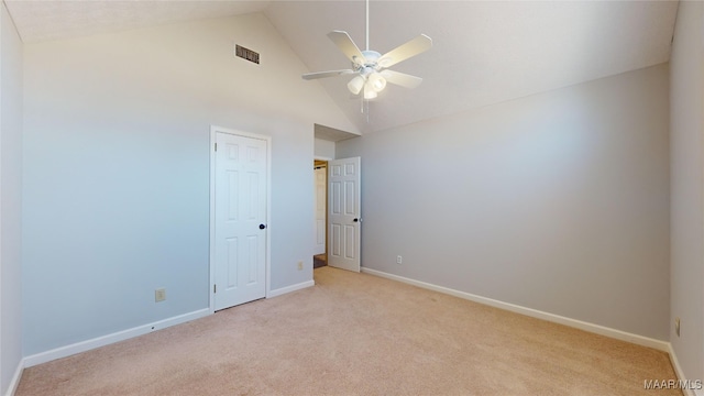 spare room featuring high vaulted ceiling, light carpet, and ceiling fan