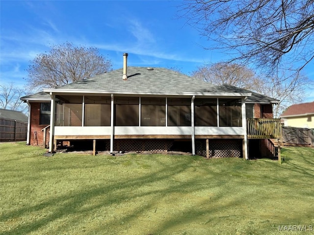 rear view of property with a yard and a sunroom