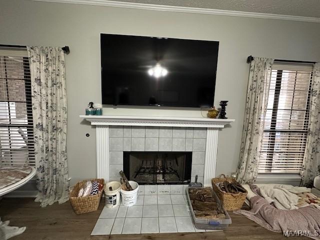 details with ornamental molding, a tiled fireplace, and a textured ceiling