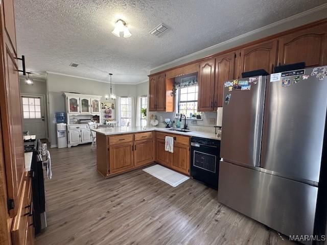 kitchen featuring pendant lighting, dishwasher, stainless steel fridge, range, and kitchen peninsula