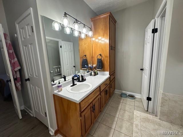 bathroom featuring tile patterned floors, vanity, and a textured ceiling