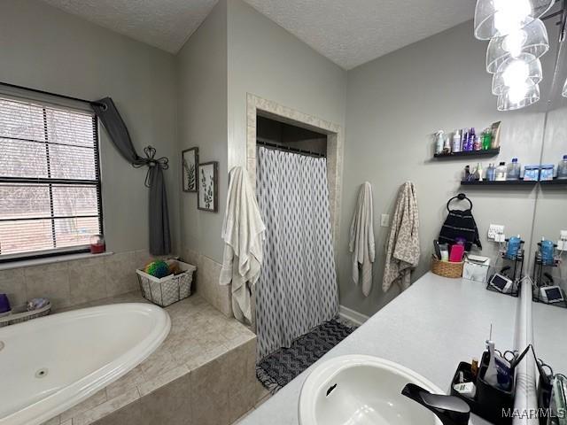 bathroom with vanity, plus walk in shower, and a textured ceiling