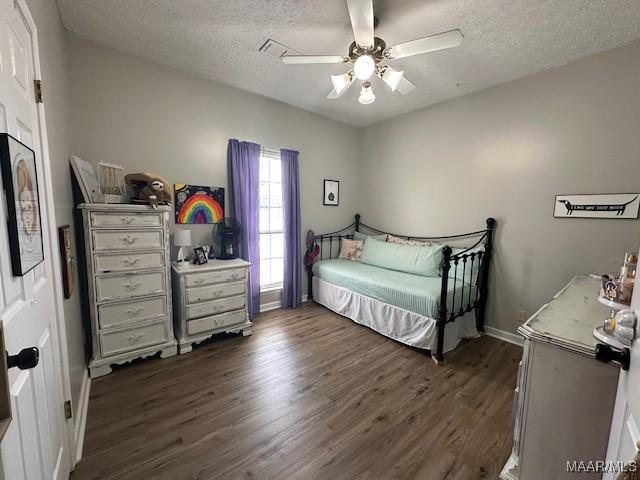 bedroom featuring a textured ceiling, dark hardwood / wood-style floors, and ceiling fan