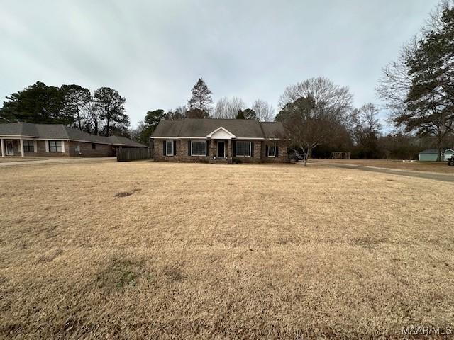 single story home featuring a front lawn