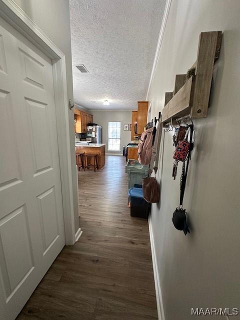 hallway with dark hardwood / wood-style floors and a textured ceiling