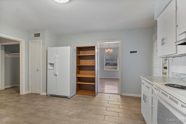 kitchen with white cabinetry, a notable chandelier, and white appliances