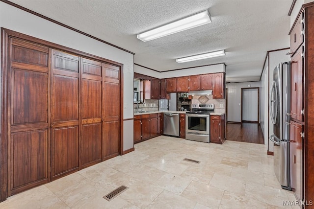 kitchen featuring sink, crown molding, a textured ceiling, appliances with stainless steel finishes, and backsplash