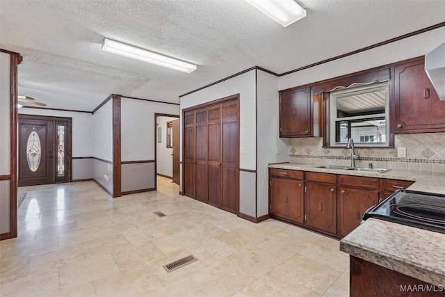 kitchen with sink, decorative backsplash, crown molding, a textured ceiling, and electric stove