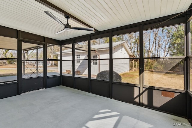 unfurnished sunroom featuring ceiling fan and a wealth of natural light