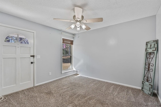 carpeted entrance foyer featuring ceiling fan and a textured ceiling