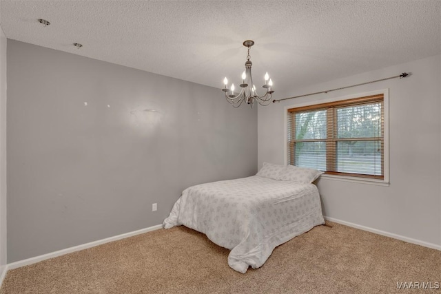 bedroom featuring carpet floors, a notable chandelier, and a textured ceiling