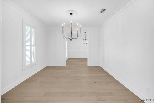 unfurnished dining area with ornamental molding, a notable chandelier, and light wood-type flooring