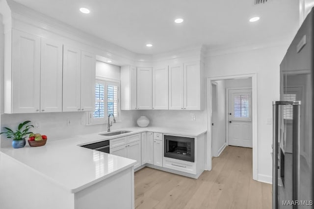 kitchen with sink, black microwave, and white cabinets