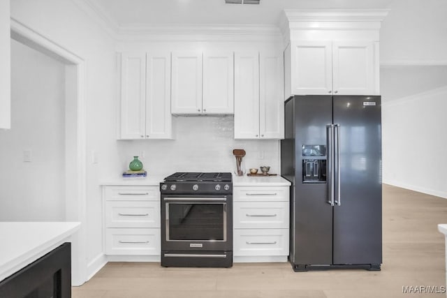 kitchen featuring stainless steel gas stove, black fridge with ice dispenser, ornamental molding, and white cabinetry