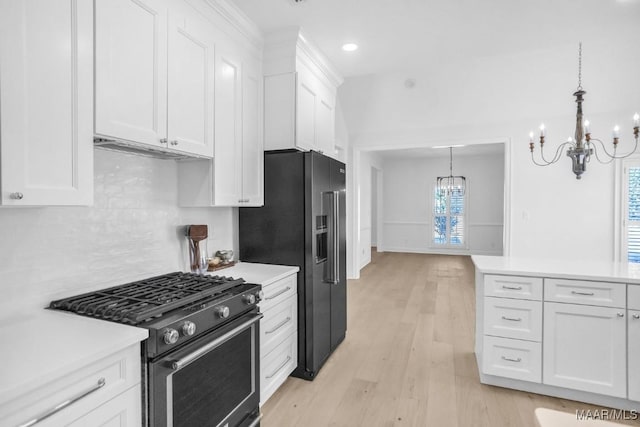 kitchen with white cabinets, range with gas stovetop, and an inviting chandelier