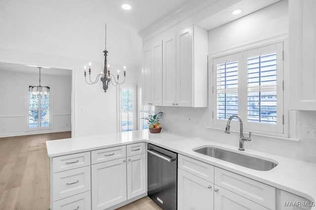 kitchen with decorative light fixtures, sink, white cabinets, stainless steel dishwasher, and a notable chandelier