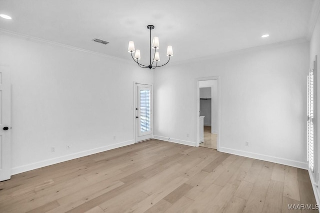 unfurnished room featuring ornamental molding, light hardwood / wood-style floors, and a notable chandelier