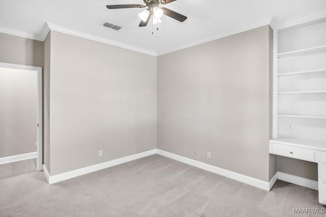 unfurnished bedroom with crown molding, built in desk, light colored carpet, and ceiling fan