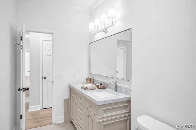 bathroom featuring ornamental molding, toilet, tile patterned flooring, and vanity