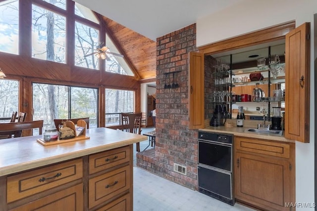 kitchen with sink, high vaulted ceiling, wooden ceiling, and ceiling fan