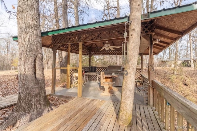 deck with exterior kitchen, area for grilling, and ceiling fan