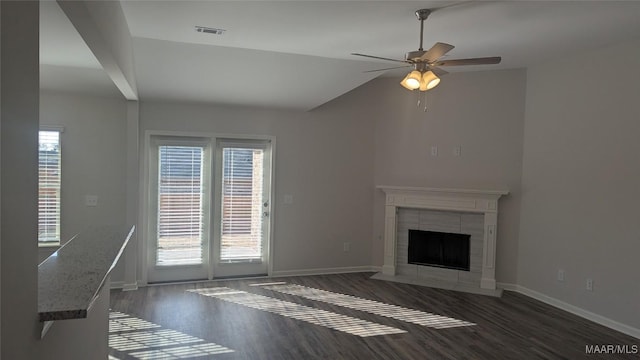 unfurnished living room featuring vaulted ceiling, dark hardwood / wood-style floors, ceiling fan, and a fireplace