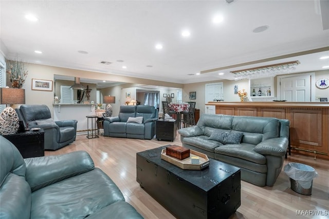 living room with crown molding and light hardwood / wood-style floors