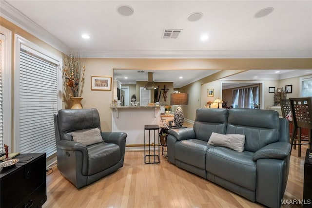 living room featuring ornamental molding and light hardwood / wood-style floors