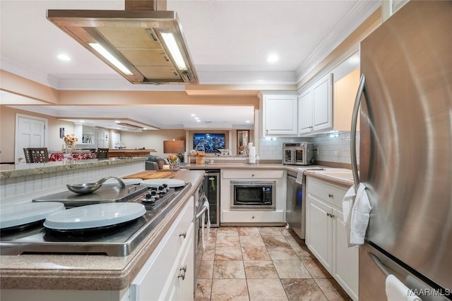 kitchen with built in microwave, white cabinetry, tasteful backsplash, stainless steel fridge, and kitchen peninsula