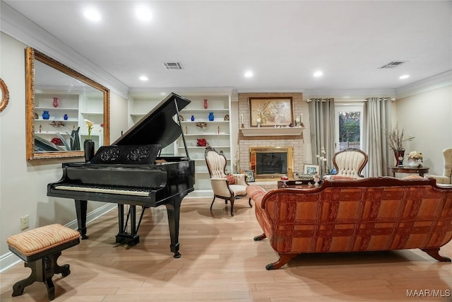 miscellaneous room featuring crown molding, a fireplace, and light wood-type flooring