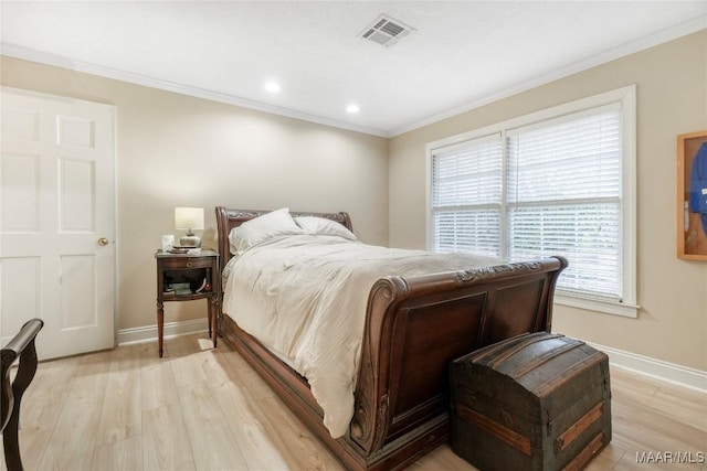 bedroom featuring crown molding and light hardwood / wood-style floors