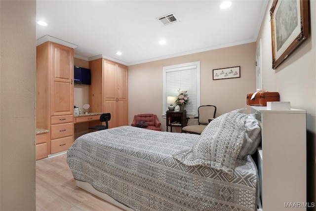 bedroom with crown molding, built in desk, and light hardwood / wood-style flooring