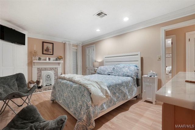 bedroom featuring ornamental molding and light hardwood / wood-style floors