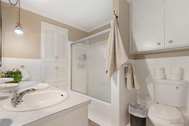 full bathroom with toilet, bath / shower combo with glass door, tile walls, ornamental molding, and vanity